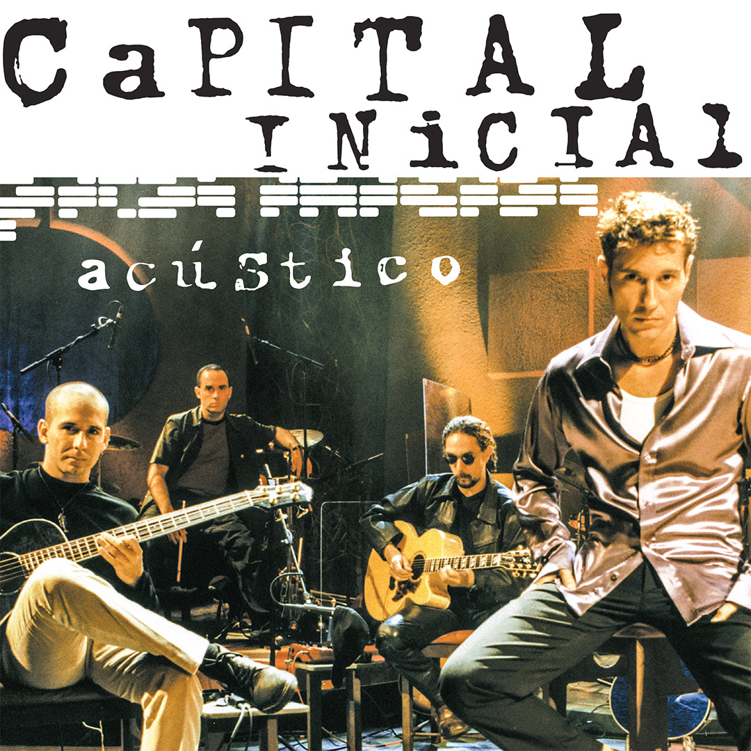Capa do álbum Acústico do Capital Inicial mostrando os quatro integrantes da banda durante uma sessão de gravação em estúdio. Dinho Ouro Preto aparece em primeiro plano à direita usando camisa acetinada cinza, enquanto os demais músicos estão sentados com violão, baixo e bateria ao fundo. O título "Capital Inicial acústico" ocupa a parte superior da capa em tipografia preta sobre fundo branco.