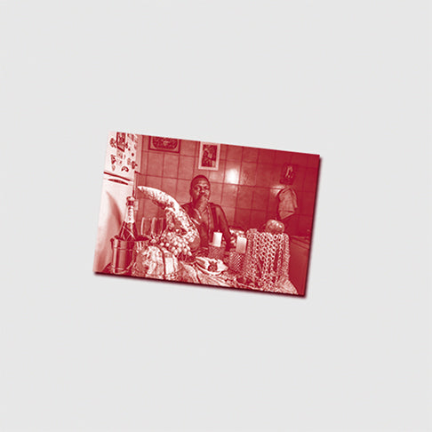 Fotografia presente no material gráfico do LP Ladrão de Djonga mostrando personagem sentado à mesa em ambiente doméstico.