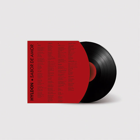 envelope interno do LP Sabor de Amor de Hyldon com letras das músicas em colunas sobre fundo vermelho acompanhado de disco de vinil preto parcialmente exposto (disco de vinil).