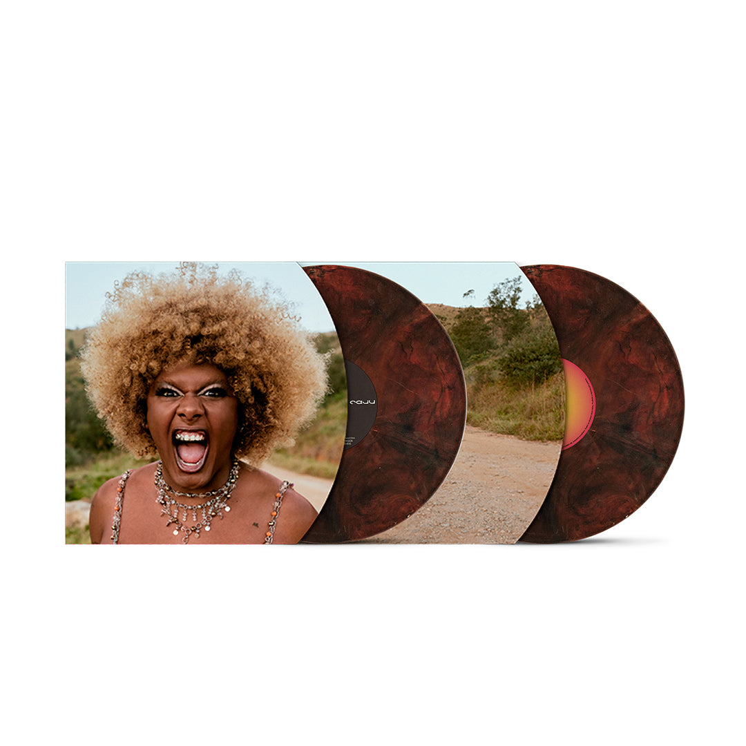 Edição em vinil de Caju, de Liniker, com capa gatefold aberta e dois discos marmorizados parcialmente expostos. A arte interna traz um retrato de Liniker em primeiro plano e uma fotografia de uma estrada em meio à paisagem, enquanto os discos apresentam efeito marmorizado em tons de marrom e vermelho.