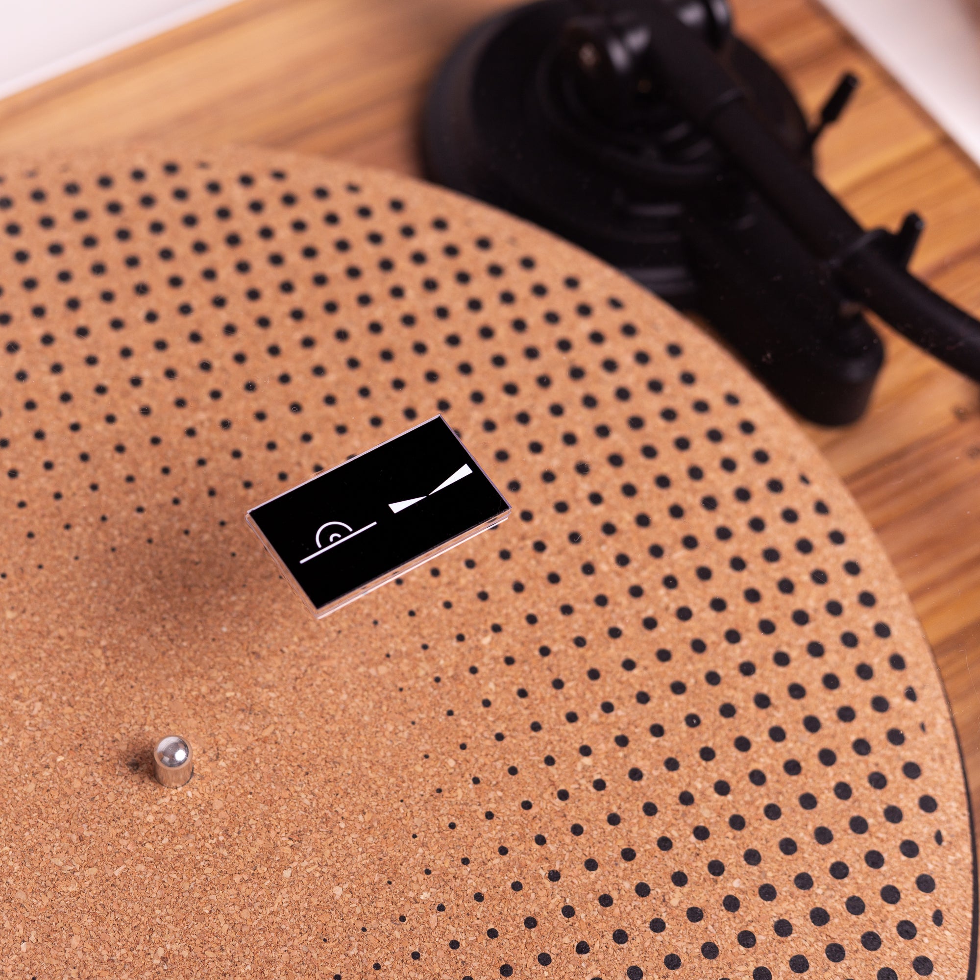Detalhe do tapete personalizado no prato do toca-discos, agregando estilo e proteção ao vinil durante a reprodução.