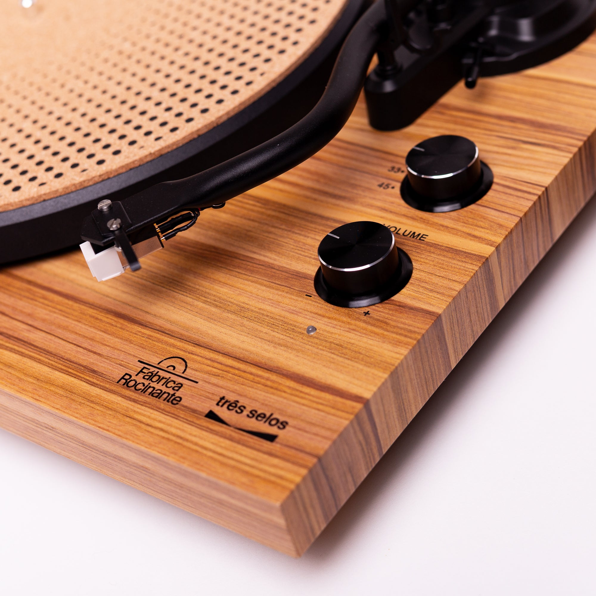 Detalhes do braço, botões de volume e RPM do toca-discos de vinil Três Selos Rocinante, com os logos "Três Selos" e "Fábrica Rocinante".